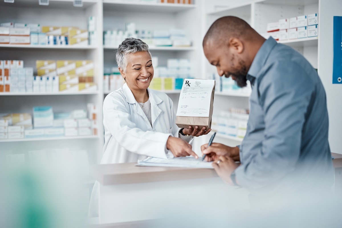 A man in a blue shirt purchases medications at a pharmacy. He pays out-of-pocket now and then delays reimbursement from his HSA.